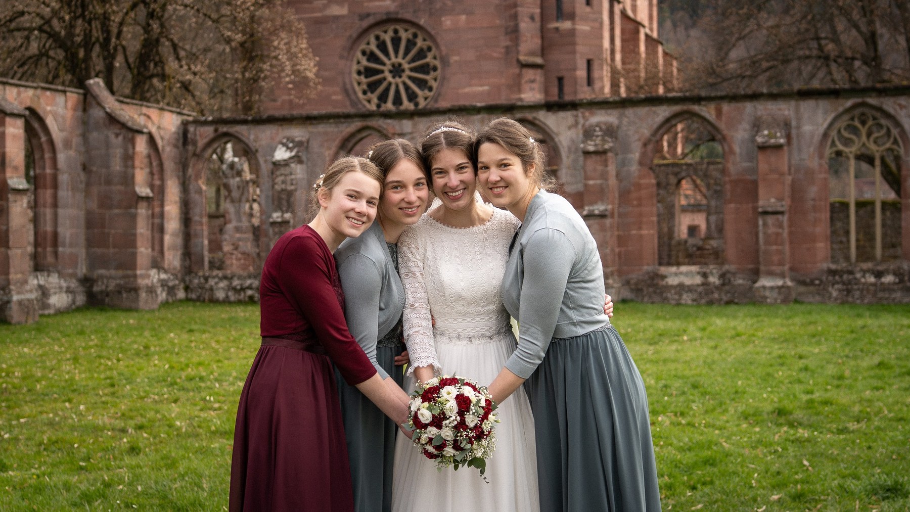 Braut und Begleiterin von hinten vor einer Kirche
